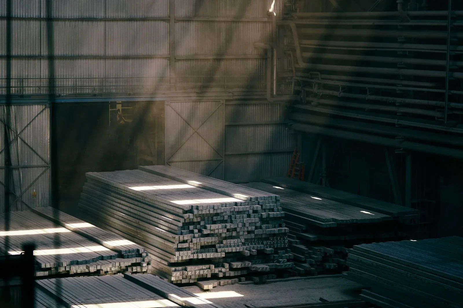 Large stacks of steel billets inside an industrial warehouse