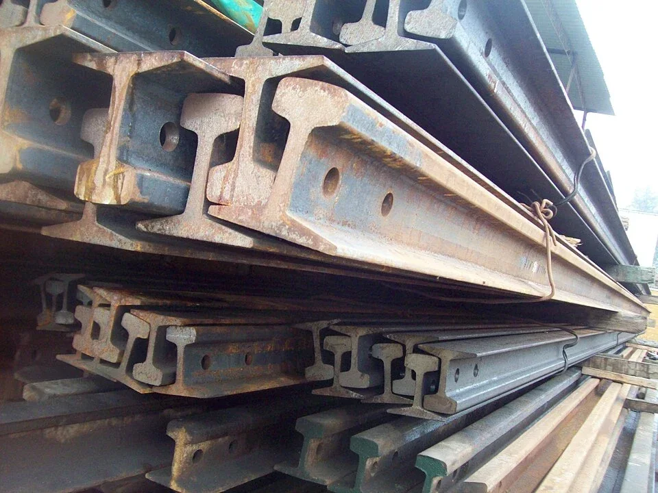 Stacked used railway rails showing their ends and profiles